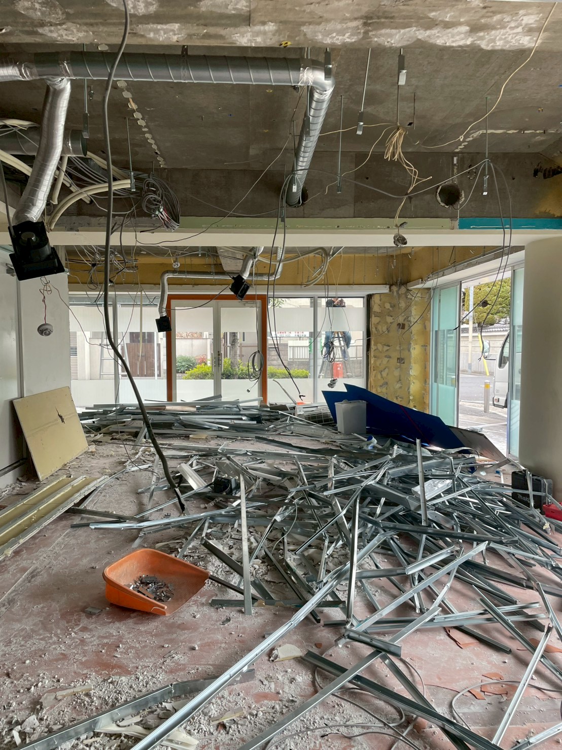 軽量鉄骨材を中心に解体廃材が床面に集積された商業テナントの搬出前状況