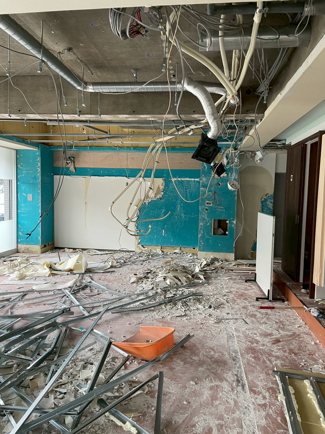 空調ダクトや配線が露出した学習塾テナント内で安全管理を行いながら進める内装解体工事