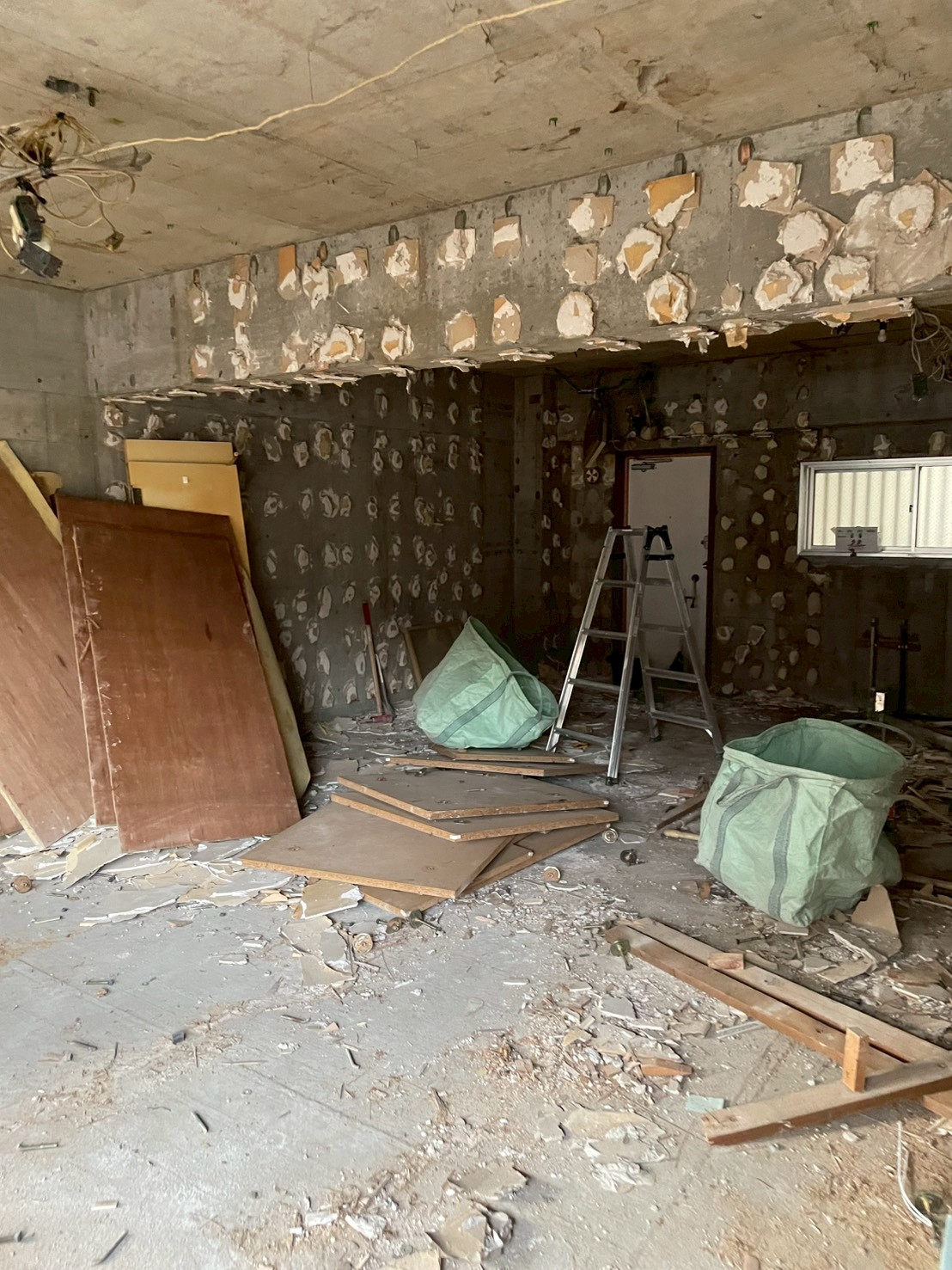 石膏ボード撤去後の壁面にGLボンド跡が残るマンション内装解体現場