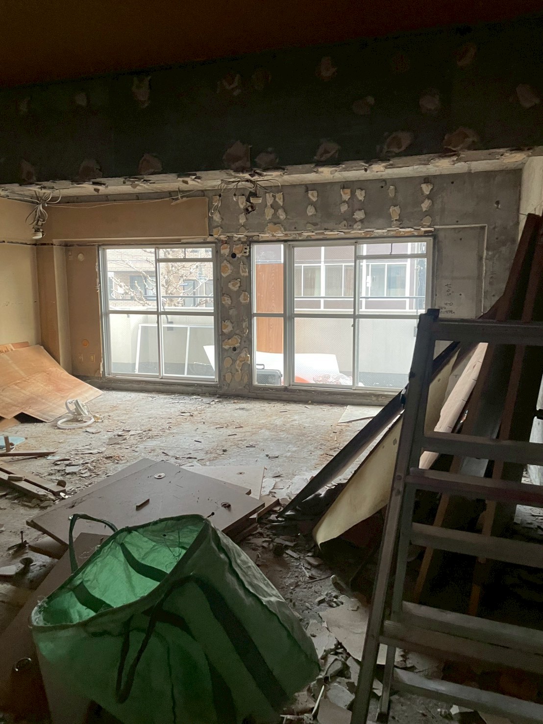 石膏ボードや木材など混合廃棄物が散在する室内解体現場の状況