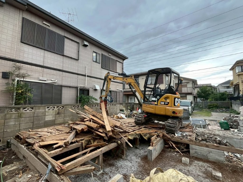 千葉県松戸市の木造住宅解体現場で3t重機を使用し木材を集積している様子