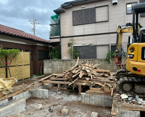 松戸市の戸建て解体工事で木材や瓦などの廃材を分別しながら重機作業を行う様子