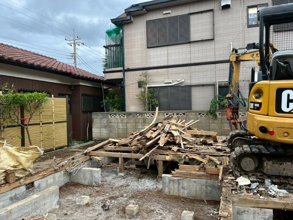 松戸市の戸建て解体工事で木材や瓦などの廃材を分別しながら重機作業を行う様子