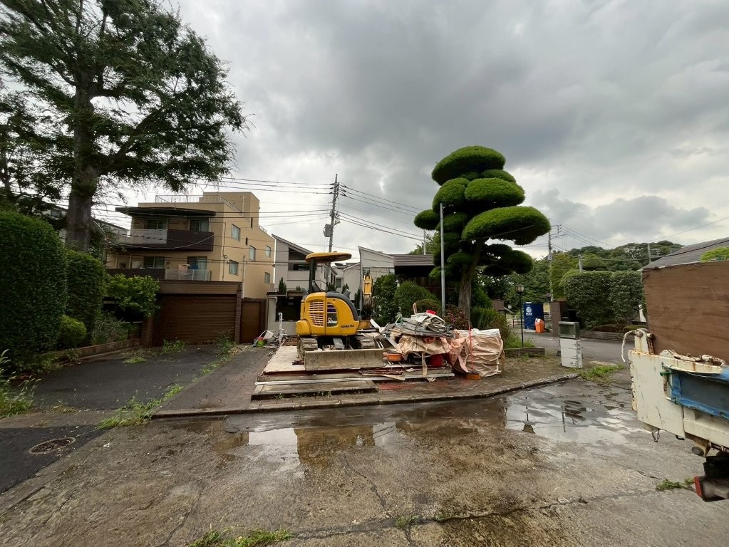 練馬区高松の事務所解体工事で小型重機を使用して木材や屋根材を撤去している様子